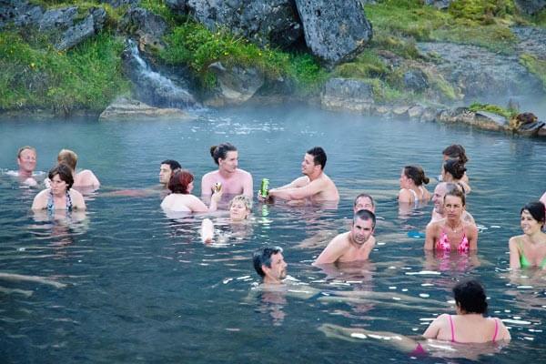 Take a dip in the natural hot springs after a hike through Landmannalaugar colored mountains.